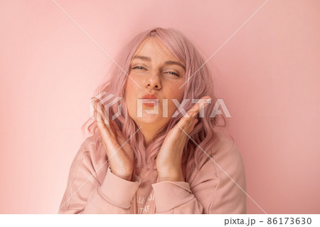 Portrait of happy and positive caucasian woman gives an air kiss over bright pink background 86173630