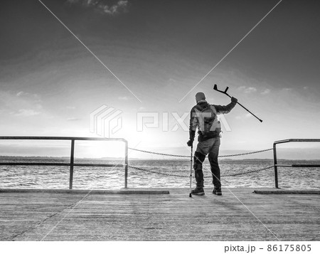 Traveler with backpack walk dificult with medicine poles. Traveler with backpack walk dificult with medicine poles. 86175805