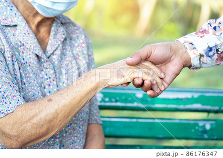 Caregiver daughter holding Touching hands Asian senior or elderly old lady woman patient with love, care, helping, encourage and empathy at nursing hospital ward, healthy strong medical concept. 86176347