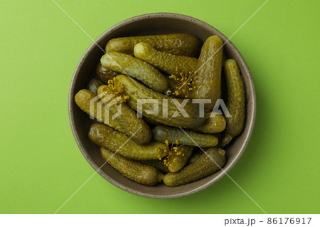Bowl of fresh pickles on green background 86176917