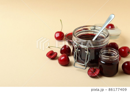 Cherry jam and ingredients on beige background Cherry jam and ingredients on beige background 86177409