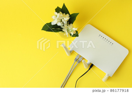 Wi-Fi router and flowers on yellow background 86177918