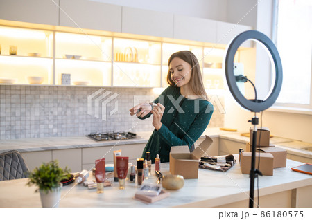 Pretty woman demonstrating new cosmetics and looking involved 86180575