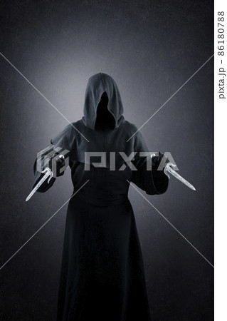 Hooded assassin with two daggers in the dark 86180788