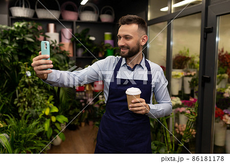florist takes a selfie on the background of refrigerators with flowers 86181178