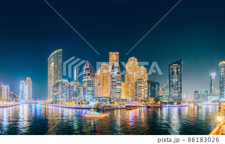 Beautiful Night view of high-rise buildings of residential district in Dubai Marina And Tourist Boat, Sightseeing Boat Sailing On Dubai Marina. Panorama, Panoramic View Beautiful Night view of high-rise buildings of residential district in Dubai Marina And Tourist Boat, Sightseeing Boat Sailing On Dubai Marina. Panorama, Panoramic View 86183026