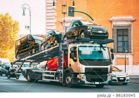 Auto-transport Carrying New Fiat Cars In European City Street. Auto Transport Broker Or Car Transporter 86183045