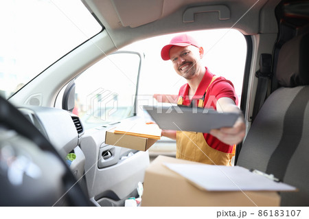 Male courier in uniform picking up documents from car 86183107