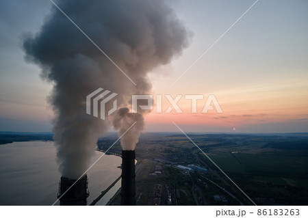 Aerial view of coal power plant high pipes with black smoke moving upwards polluting atmosphere at sunset. Production of electrical energy with fossil fuel concept Aerial view of coal power plant high pipes with black smoke moving upwards polluting atmosphere at sunset. Production of electrical energy with fossil fuel concept 86183263