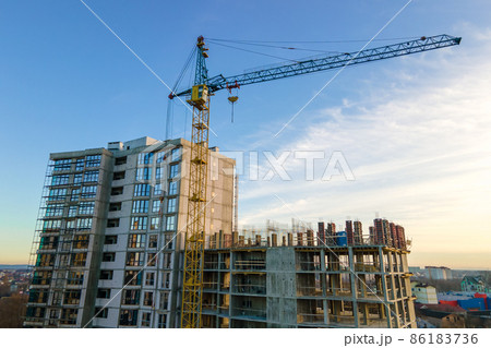 Aerial view of high tower crane and residential apartment buildings under construction. Real estate development. 86183736