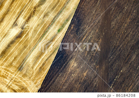 Aerial view of plowed agricultural field prepared for planting crops in spring Aerial view of plowed agricultural field prepared for planting crops in spring 86184208