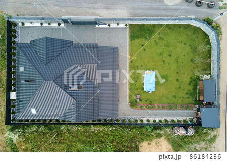 Aerial view of private house with green backyard and small swimming pool on grass lawn. 86184236