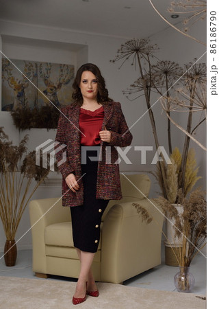 A beautiful young girl posing in a light armchair. 86186790