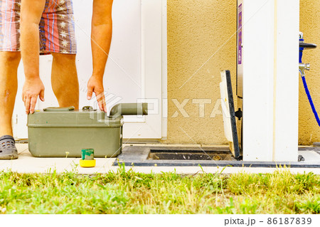 Man emptying caravan tank toilet cassette in dump station. Man emptying caravan tank toilet cassette in dump station. 86187839