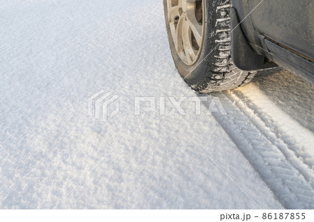 the track of a car wheel in the snow 86187855