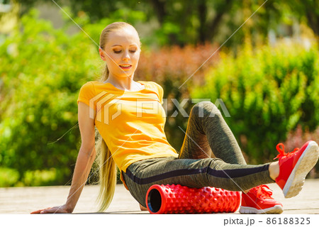 Girl doing exercises outdoor, using roller Girl doing exercises outdoor, using roller 86188325