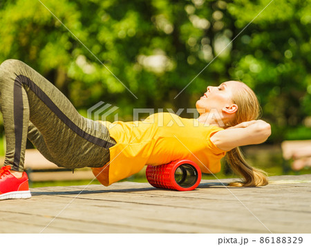Girl doing exercises outdoor, using roller Girl doing exercises outdoor, using roller 86188329