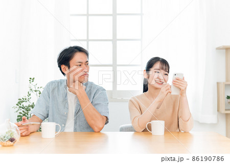 女性のスマホをのぞく男性（怒る） 86190786