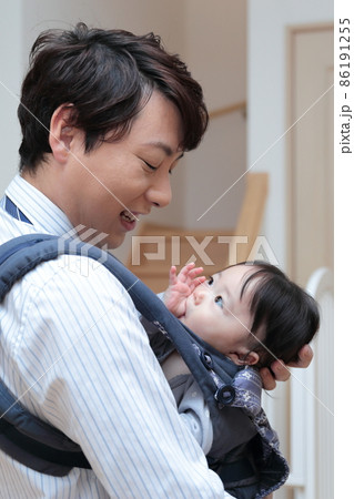 赤ちゃんを抱っこする会社員のパパの写真素材