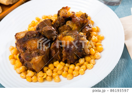 Braised oxtails with chickpeas on a white plate 86193597