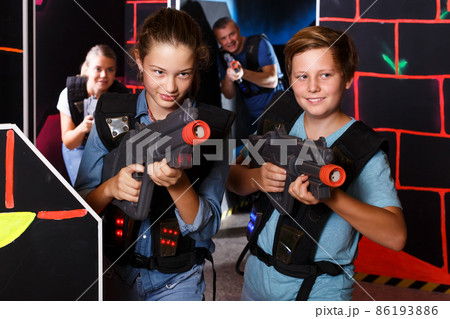 Teenage kids playing lasertag Teenage kids playing lasertag 86193886