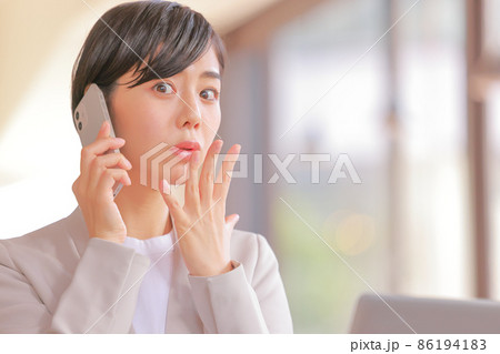 電話の話に驚いて目を丸くするビジネスウーマン_クローズアップ1 電話の話に驚いて目を丸くするビジネスウーマン_クローズアップ1 86194183