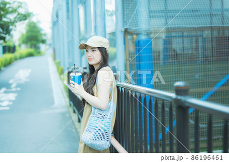 アイスコーヒーを飲みながら歩く女性 アイスコーヒーを飲みながら歩く女性 86196461