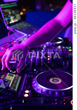 Close-Up of Dj Mixer Controller Desk in Night Club Disco Party. DJ Hands touching Buttons and 86196837