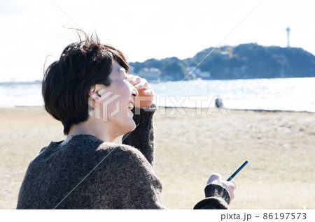 江ノ島でスマホを見る男性 86197573