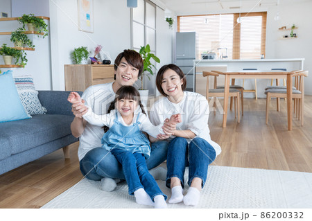 自宅のリビング座ってふざける小学生の女の子とパパとママのポートレート 自宅のリビング座ってふざける小学生の女の子とパパとママのポートレート 86200332