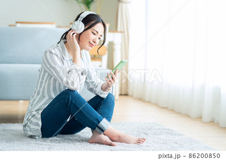 女性　スマホ　ヘッドフォン　ライフスタイル　リビング 86200850