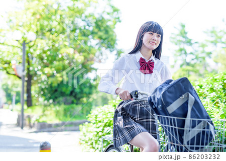笑顔で自転車通学する女子高校生 住宅地 市街地 綺麗な新緑 笑顔で自転車通学する女子高校生 住宅地 市街地 綺麗な新緑 86203232