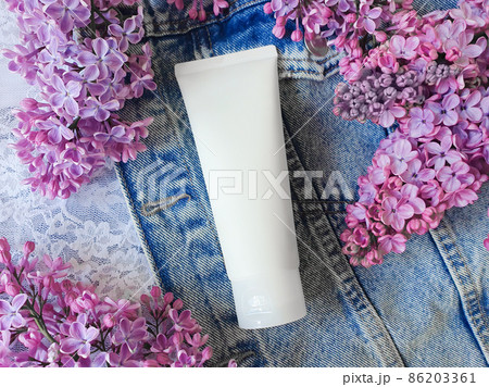 Mockup of white squeeze bottle plastic tube for branding - cream, gel, skincare, moisturize. Cosmetic container and pink lilac flowers on denim clothing background. Top front view, mockup. Mockup of white squeeze bottle plastic tube for branding - cream, gel, skincare, moisturize. Cosmetic container and pink lilac flowers on denim clothing background. Top front view, mockup. 86203361