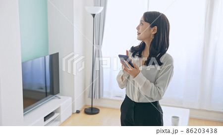 部屋でスマホを使う女性 86203438