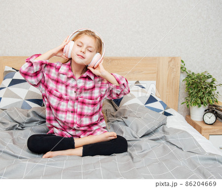 Cute girl listening music in the bedroom Cute girl listening music in the bedroom 86204669