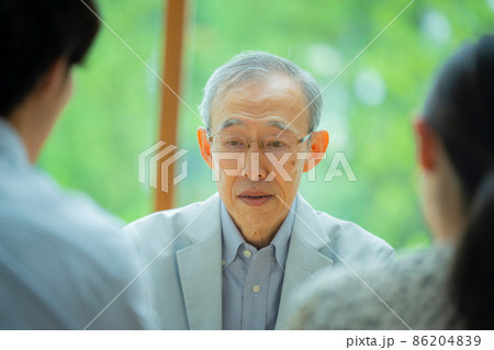 会話するシニア男性と若い夫婦 86204839