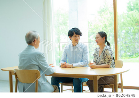 会話するシニア男性と若い夫婦 会話するシニア男性と若い夫婦 86204849