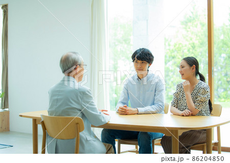 会話するシニア男性と若い夫婦 会話するシニア男性と若い夫婦 86204850