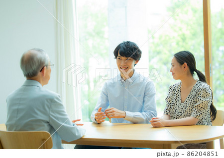 会話するシニア男性と若い夫婦 会話するシニア男性と若い夫婦 86204851