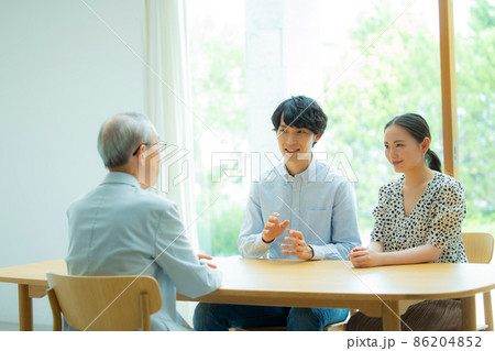 会話するシニア男性と若い夫婦 86204852