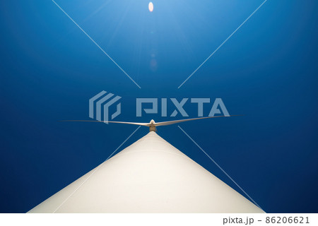 Large three-bladed horizontal-axis wind turbine against clear blue sky. Dramatic view from below Large three-bladed horizontal-axis wind turbine against clear blue sky. Dramatic view from below 86206621