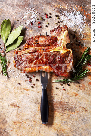 porterhouse steak is speared with carving fork porterhouse steak is speared with carving fork 86208051