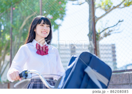 笑顔で自転車を押して通学する女子高校生　見上げ構図　住宅地　市街地　 86208085