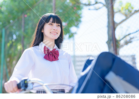 笑顔で自転車を押して通学する女子高校生 見上げ構図 住宅地 市街地 笑顔で自転車を押して通学する女子高校生 見上げ構図 住宅地 市街地 86208086