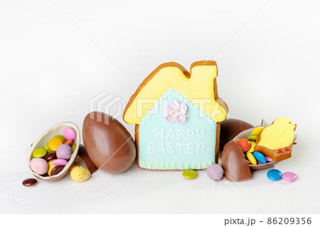 Broken Easter chocolate eggs and colorful decorations on a light background. Banner. Easter concept, easter treats. Flat lay, top view. 86209356