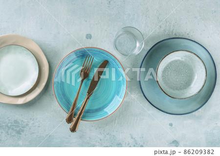 Modern dinnerware with cutlery. A vibrant blue plate with a fork and a knife Modern dinnerware with cutlery. A vibrant blue plate with a fork and a knife 86209382