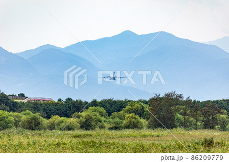 山に向かって飛ぶ飛行機 86209779