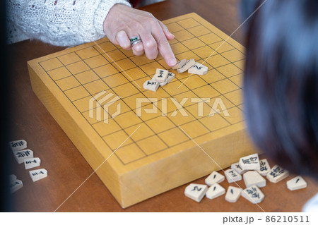 将棋の山くずしをして遊ぶシニア女性 将棋の山くずしをして遊ぶシニア女性 86210511