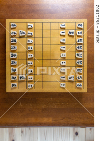 将棋盤と並べてある将棋の駒 86211802