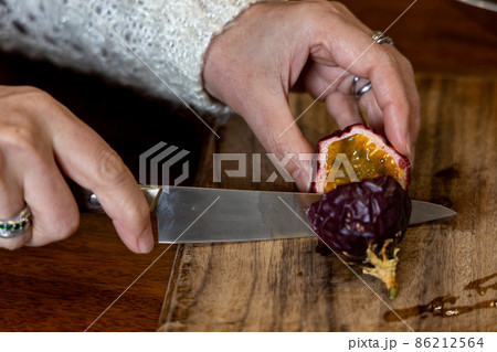 熟れたパッションフルーツの実を切って食べようとしているところ 86212564